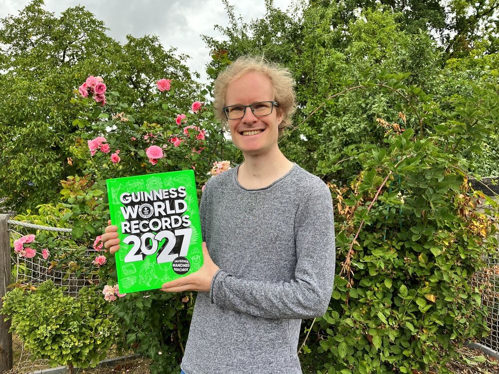 Christian Schäfer hält lächelnd das neue Guinness World Records 2027 in den Händen